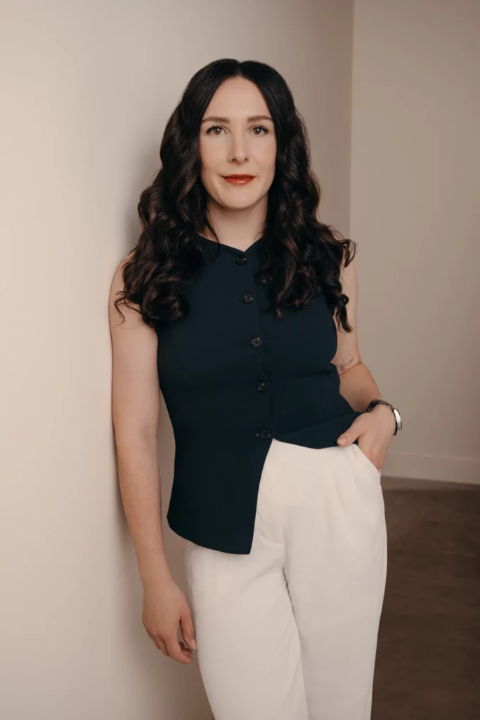 Person posing against beige wall indoors