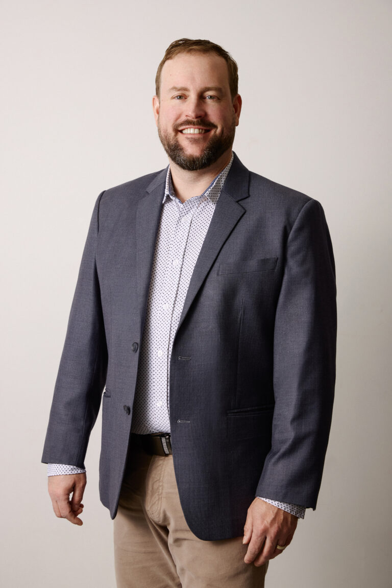 Smiling man in blazer against neutral background