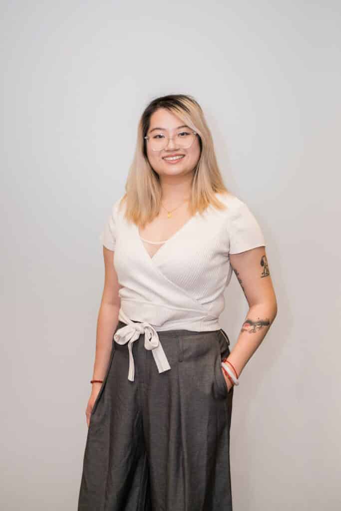 Smiling woman with glasses and arm tattoos