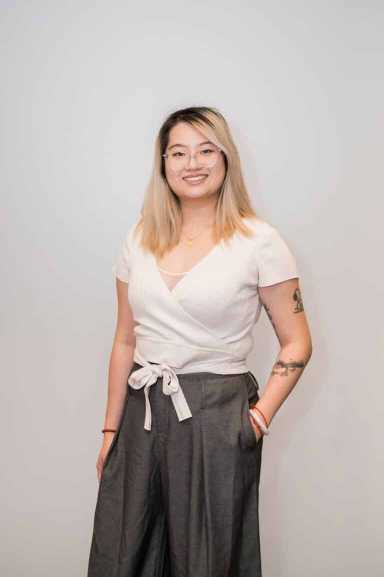 Smiling woman with glasses and arm tattoos